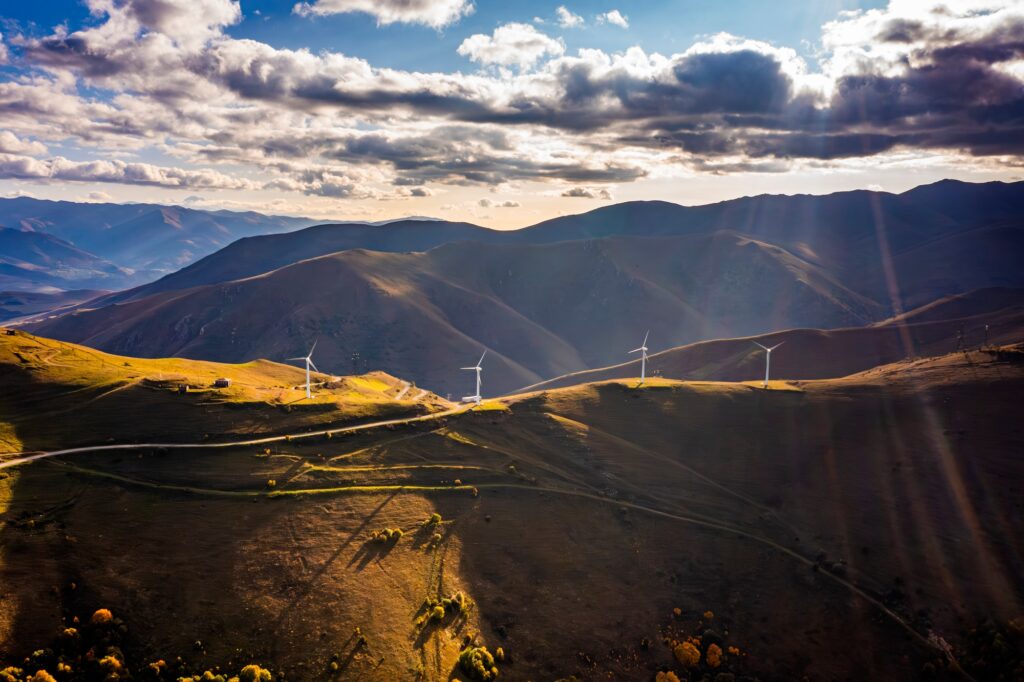 Aerial shot of a landscape and a wind turbine on a mountain